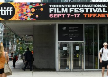 People walk past TIFF placards in Toronto, Canada on the TIFF opening day, on September 7, 2023. – The biggest film festival in North America opens Thursday in Toronto with the international launch of Oscar-winning Japanese animation master Hayao Miyazaki’s likely last movie, as the twin Hollywood strikes drag on. (Photo by VALERIE MACON / AFP)