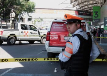 A police officer cordons off an area after a shooting outside of the Benito Juarez International Airport in Mexico City on September 12, 2023. – An alleged thief opened fire Tuesday outside Mexico City’s main international airport during a police chase that left two officers injured and briefly caused panic among travelers, authorities said. (Photo by VALENTINA ALPIDE / AFP)