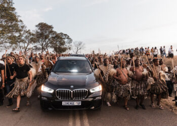 Amabutho (Zulu regiments) sing and chant praises in front of a convoy carrying the coffin of Mangosuthu Buthelezi, traditional prime minister of the Zulu monarch and nation, as it passes through Mahlabathini on its way to his family’s rural home at Kwa-Phindangene, in Ulundi on September 15, 2023, a day before his funeral. (Photo by RAJESH JANTILAL / AFP)