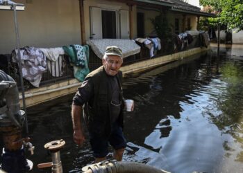 A man walks in his flooden house in the flooded village of Palamas near the city of Karditsa, central Greece, on September 8, 2023. – Firefighters backed by the army were rescuing hundreds of people Saturday in villages in central Greece blocked off by floods that have claimed at least 10 lives. (Photo by Sakis MITROLIDIS / AFP)