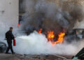 A member of Israeli security forces tries to extinguish fire on cars following a rocket attack from the Gaza Strip in Ashkelon, southern Israel, on October 7, 2023. – Palestinian militant group Hamas has launched a “war” against Israel, Defence Minister Yoav Gallant said, after barrages of rockets were fired from the Gaza Strip into Israeli territory on October 7. (Photo by AHMAD GHARABLI / AFP)