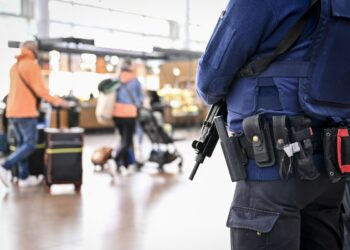 A policeman stands guard in the departure hall of Brussels Airport, in Zaventem on October 17, 2023, after the suspected perpetrator of the attack in Brussels was shot dead during a police intervention. - The suspect in the Brussels killing of two Swedish football fans was shot and fatally wounded by police during his arrest on October 17, 2023, officials said. (Photo by DIRK WAEM / BELGA / AFP) / Belgium OUT / BELGIUM OUT