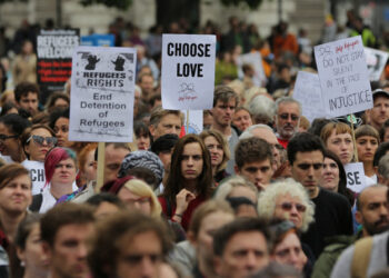 Demonstrators listen to speeches after taking part in a march calling for the British parliament to welcome refugees in the UK in central London on September 17, 2016. Thousands marched in central London calling on the British government to do more to help refugees fleeing conflict and persecution. (Photo by Daniel LEAL / AFP)