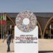 A man walks past the emblem of the 2023 IMF and World Bank annual meetings situated at the entrance of the venue in Marrakesh on October 8, 2023. (Photo by FADEL SENNA / AFP)