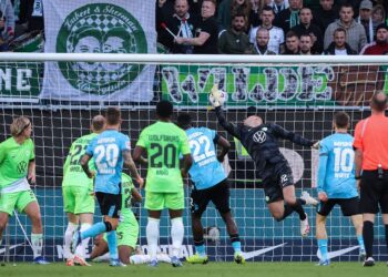 Bayer Leverkusen’s Spanish defender #20 Alejandro Grimaldo (3rd L) scores the 2-1 goal against Wolfsburg’s Austrian goalkeeper #12 Pavao Pervan (3rd R) during the German first division Bundesliga football match between VfL Wolfsburg and Bayer Leverkusen in Wolfsburg, northern Germany on October 21, 2023. (Photo by Ronny Hartmann / AFP)