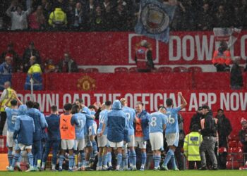 City players celebrate in front of their fans after the English Premier League football match between Manchester United and Manchester City at Old Trafford in Manchester, north west England, on October 29, 2023. – City won the game 3-0. (Photo by Paul ELLIS / AFP)