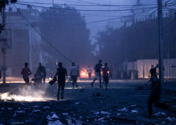 People run along a debris-strewn street following Israeli air strikes in Gaza City on October 7, 2023. (Photo by Mohammed ABED / AFP)