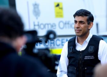 Britain’s Prime Minister Rishi Sunak speaks to the press alongside an immigration van at Wembley Police Station in northwest London on June 15, 2023. (Photo by SUSANNAH IRELAND / POOL / AFP)