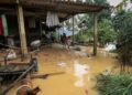 Children stand outside a house next to flood waters in Huong Khe district in central Vietnam’s Ha Tinh province on October 31, 2023. – Three people died after days of heavy rain in central and north Vietnam that flooded homes and submerged roads, disaster management authorities said October 31. (Photo by Ha Linh / AFP)