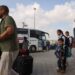 People prepare to board a bus as dual national Palestinians and foreigners get ready to cross the Rafah border point with Egypt, in the southern Gaza Strip, on November 2, 2023. – Egypt will help evacuate “about 7,000” foreigners and dual nationals from the war-ravaged Gaza Strip, the foreign ministry said, with officials saying some 400 people were expected to cross on November 2. (Photo by Mohammed ABED / AFP)