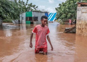 A Somali boy moves through floodwaters in Dolow on November 25, 2023. – East Africa is experiencing torrential rainfall and floods linked to El Ni–o climate pattern. Hundreds of thousands have been forced to flee their homes after the devastating floods caused by the heavy rains struck parts of the Horn of Africa, exacerbating the already existing humanitarian crisis in Somalia. (Photo by Hassan Ali Elmi / AFP)