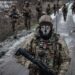 — AFP PICTURES OF THE YEAR 2023 — Ukrainian servicemen walk on the road toward their base near the frontline in the Donetsk region on February 4, 2023, amid the Russian invasion of Ukraine. (Photo by YASUYOSHI CHIBA / AFP)