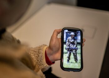 (FILES) This picture taken on February 22, 2023 shows Rina Gonoi, a former member of Japan’s Ground Self-Defense Force who was sexually assaulted by colleagues, checking old photos on her phone during an interview with AFP in Tokyo. – A Japanese court is due on December 12, 2023 to give a verdict in a landmark trial of three ex-soldiers accused of sexual assault in a country where still very few victims come forward. Gonoi, 24, won praise but also hate when she went public last year — after a military probe found insufficient evidence — accusing the fellow soldiers of assaulting her while others watched and laughed. (Photo by Philip FONG / AFP) / TO GO WITH “JAPAN-ASSAULT-COURT-GENDER-MILITARY”, ADVANCER BY KYOKO HASEGAWA – TO GO WITH “Japan-assault-court-gender-military”, ADVANCER by Kyoko HASEGAWA