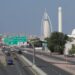 Traffic flows past Dubai’s Gargash mosque (R) and its landmark Burj al-Arab (C) luxury hotel on December 10, 2023. – The United Arab Emirates suffers from high air pollution levels fed by its fossil fuel industry, Human Rights Watch warned earlier this month, as the oil-rich country hosts the UN’s COP28 climate talks in Dubai. (Photo by Giuseppe CACACE / AFP)