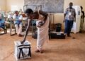 A voter casts her ballot at a polling station at Bwakya school in Lubumbashi on December 21, 2023. – Voting continued in the Democratic Republic of Congo on December 21, 2023 in a general election marked by severe logistical troubles that meant some polling stations never opened. (Photo by Patrick Meinhardt / AFP)