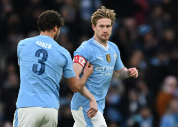 Manchester City's Portuguese defender #03 Ruben Dias (L) passes the captain's armband to Manchester City's Belgian midfielder #17 Kevin De Bruyne (R) during the English FA Cup third round football match between Manchester City and Huddersfield Town at the Etihad Stadium in Manchester, north west England, on January 7, 2024. (Photo by Paul ELLIS / AFP) / RESTRICTED TO EDITORIAL USE. NO USE WITH UNAUTHORIZED AUDIO, VIDEO, DATA, FIXTURE LISTS, CLUB/LEAGUE LOGOS OR 'LIVE' SERVICES. ONLINE IN-MATCH USE LIMITED TO 120 IMAGES. AN ADDITIONAL 40 IMAGES MAY BE USED IN EXTRA TIME. NO VIDEO EMULATION. SOCIAL MEDIA IN-MATCH USE LIMITED TO 120 IMAGES. AN ADDITIONAL 40 IMAGES MAY BE USED IN EXTRA TIME. NO USE IN BETTING PUBLICATIONS, GAMES OR SINGLE CLUB/LEAGUE/PLAYER PUBLICATIONS. - RESTRICTED TO EDITORIAL USE. No use with unauthorized audio, video, data, fixture lists, club/league logos or 'live' services. Online in-match use limited to 120 images. An additional 40 images may be used in extra time. No video emulation. Social media in-match use limited to 120 images. An additional 40 images may be used in extra time. No use in betting publications, games or single club/league/player publications. /