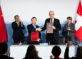 Swiss Federal Minister Guy Parmelin (Front R), and Wang Shouwen, Chinese Vice Minister of the Ministry of Commerce, shake hands after signing a joint statement of the free trade agreement as Swiss President Viola Amherd (Back-R), and Chinese Prime Minister Li Qiang (Back L) applaude, during an official visit to Kehrsatz, near Switzerland’s administrative capital Bern on January 15, 2024. – Li Qiang, is visiting Switzerland to attend the 54th World Economic Forum Annual (WEF) which is taking place from January 14-19 in Davos. (Photo by PETER KLAUNZER / POOL / AFP)