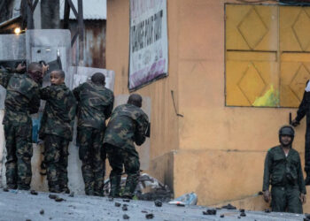 Security forces face opposition demonstrators throwing stones at them in Moroni, on January 18, 2024 following the announcement of the presidential election results. - The Comoros declared a curfew on January 17, 2024 after security forces clashed with protesters angered by the re-election of President Azali Assoumani in a vote opposition leaders denounced as fraudulent. (Photo by OLYMPIA DE MAISMONT / AFP)