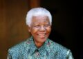 Former South African President Nelson Mandela smiles for photographers after a meeting with actor Tim Robbins at Mandela's home in Johannesburg September 22, 2005. REUTERS/Mike Hutchings