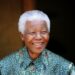 Former South African President Nelson Mandela smiles for photographers after a meeting with actor Tim Robbins at Mandela's home in Johannesburg September 22, 2005. REUTERS/Mike Hutchings