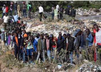 Onlookers gather at the dumpsite where six bodies were found in the landfill in Mukuru slum, Nairobi, on July 12, 2024. (AFP)